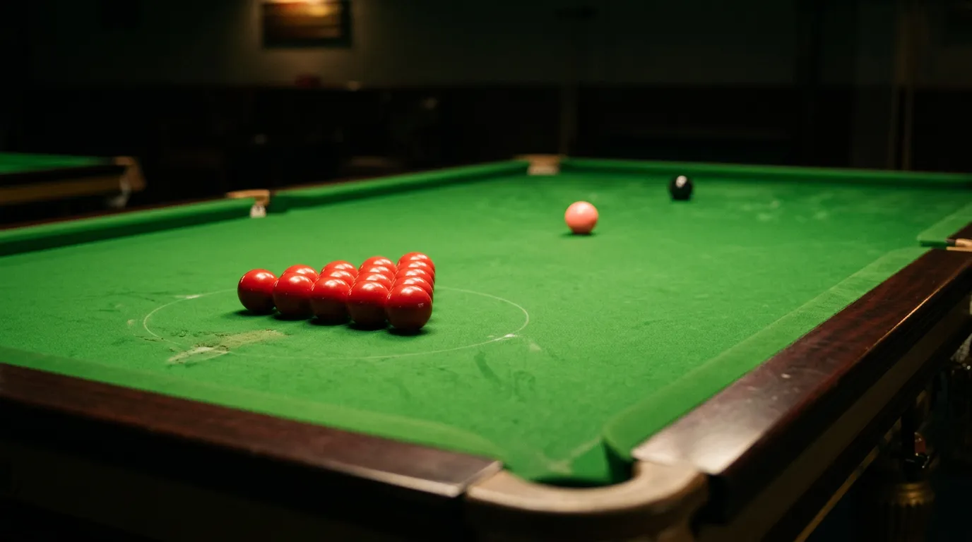 Close-up of a snooker table with coloured balls arranged on green baize