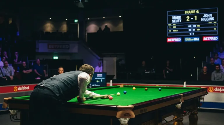 Professional snooker match in progress with electronic scoreboard displaying frame count